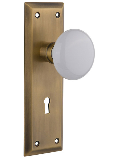 Classic New York Style Mortise Lock Set in Antique Brass with White Porcelain Door Knobs.